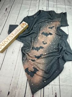 a bat t - shirt laying on top of a wooden floor next to a tube of toothpaste