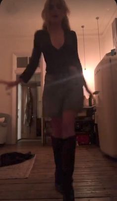 a woman is standing in the middle of a room with her legs spread wide open