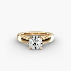 a yellow gold engagement ring with a single diamond