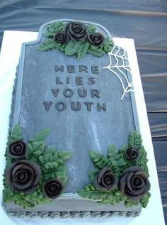 a tombstone with roses on it that says here lies your youth in frosting and spider webs