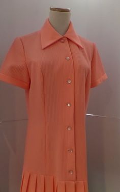 This salmon pink dress is vintage hipster with its dropped waist and accordian pleats. It has a 1920s style with the silhouette. The label is A Yardley Fashion. It is machine washable. Twiggy wore one of Gibbs dresses to her premiere which heightened the popularity of his label. He became perhaps most famous for his extraordinary knitwear designs, undeniably inspired by his Scottish origins. Initially hand machined by Mildred Boulton, who worked from Gibb's designs and Kaffe Fassett's swatches, Pink Fitted Dress With Accordion Pleats, Fitted Pink Dress With Accordion Pleats, Retro Pink Dress For Work, Pink Retro Dress For Work, Spring Retro Pleated Vintage Dress, Pink Retro Vintage Dress For Formal Occasions, Retro Pink Dress With Buttons, Vintage Pink Collared Dress, Pink Vintage Collared Dress