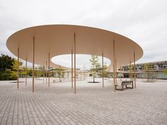 an empty park with benches and trees in the background