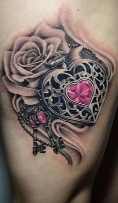 a chest tattoo with a heart and key on it's side, next to a rose