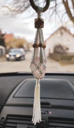 a car dashboard with a steering wheel hanging from it's center console and beads