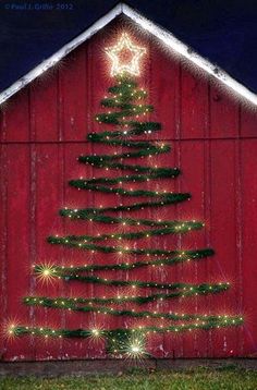 a christmas tree on the side of a red barn