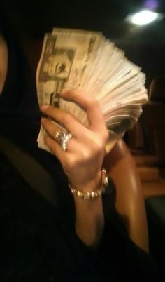 a woman is holding cash in her hand