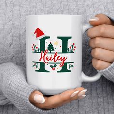 a woman is holding a coffee mug with the word holly on it and christmas decorations