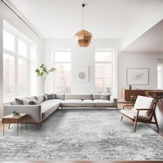 a modern living room with white walls and wood flooring, large sectional couches