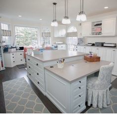 a large kitchen with white cabinets and an island