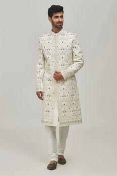 White sherwani with thread floral embroidery all-over and welt pocket in front. Comes with churidar.
Components:2
Pattern:Embroidery
Type of Work:Thread
Neckline:Mandarin Collar
Sleeve Type:Long
Fabric:Silk and Art Silk
Color:White
Other Details:
Closure: Button front
Note: 
Pocket square worn by the model is not for sale
The fabric is silk blend and not pure silk
Occasion:Groom - Aza Fashions Cream Churidar With Floral Embroidery For Wedding, Elegant Floral Embroidered Churidar For Weddings, Cream Sherwani With Chikankari Embroidery And Long Sleeves, Cream Long Sleeve Sherwani With Chikankari Embroidery, Eid Intricate Embroidered Straight Kurta Bandhgala, Cream Churidar With Floral Embroidery For Eid, Off White Unstitched Bandhgala With Long Sleeves, Unstitched Off White Bandhgala With Long Sleeves, Festive Semi-stitched Sherwani With Floral Embroidery