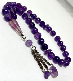 Discover the beauty and serenity of these Antique Natural Brazilian Amethyst Prayer Beads, meticulously crafted to bring peace and tranquility to your spiritual journey. This exquisite rosary is a true gem, both in its timeless design and the healing properties of the natural amethyst stones. Handpicked for their stunning color and clarity, each bead is carefully strung together to create a seamless flow, making it a pleasure to hold and use during prayer or meditation. The smooth texture of the amethyst beads adds a soothing touch to your fingertips, enhancing the overall experience. Amethyst, known as the stone of spirituality and contentment, is believed to promote inner peace, balance, and clarity of mind. Its calming energy can help alleviate stress and anxiety, allowing you to connec Natural Stone Rosary With Round Beads For Meditation, Rosary With Natural Stones For Meditation, Elegant Healing Rosary With Round Beads, Elegant Rosary With Round Beads For Healing, Elegant Healing Rosary, Spiritual Polished Rondelle Beads, Handmade Amethyst Beads For Jewelry Making, Purple Round Bead Gemstones For Gifts, Purple Rosary With 8mm Round Beads