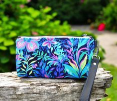 Floral wristlet purse, this zippered pouch would make a fun addition to any handcrafted purse collection or give as a unique gift that is ready to ship! On this floral bag custom print cotton lycra fabric with bold colors and a combination of flowers, plants and leaves is combined with a mottled black/blue for the liner and a black vinyl wrist strap. On the inside there is a slip pocket on each side made with the same floral fabric.  FABRIC IS BRIGHTER THAN THE PICTURES! My camera wasn't picking Multicolor Wristlet With Cell Phone Pocket As Gift, Multicolor Zipper Pouch Wristlet Clutch, Multicolor Zipper Pouch Wristlet, Handmade Pouch Wristlet For Daily Use, Multicolor Wristlet Clutch With Zipper, Handheld Wristlet With Zipper Pouch For Gift, Handheld Wristlet With Zipper Pouch As Gift, Multicolor Wristlet With Removable Pouch As Gift, Handmade Clutch Wristlet For Everyday Use