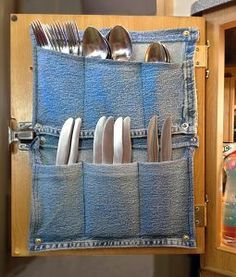 an open denim pocket holds silverware and utensils in front of a wooden cabinet