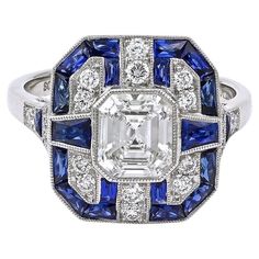 A Sophia D. ring that features a 1.03 carat center diamond accented with 1.09 carats of blue sapphires and 0.27 carats of diamonds. Set in platinum. Sophia D by Joseph Dardashti LTD has been known worldwide for 35 years and are inspired by classic Art Deco design that merges with modern manufacturing techniques. Ascher Cut, Most Popular Engagement Rings, Popular Engagement Rings, Trending Engagement Rings, Art Deco Diamond Rings, Ring Trends, French Cut, Modern Ring, 18k Yellow Gold Ring