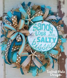 a wreath made out of burlocks and ribbons with the words sandy toes and salty kisses on it