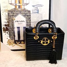 Nwot Very Classy "Iman" Croc Embossed Black & Gold Large Vegan Leather Handbag, Detachable Tassel, 4 Gold Feet, Inside Zip Pocket, Clean Signature Monogram Tan Inside Lining. Beautiful Shiny Gold Hardware! No Call Outs! *Approx: 11" H X 9" W X 6" D Handles 5" No Pets, No Smoke, No Flaws *Shoes Sold Separately!! Black Handheld Box Bag With Gold-tone Hardware, 6 D, Leather Handbag, Emboss, Gold Hardware, Leather Handbags, Vegan Leather, Zip Pockets, Bag Lady