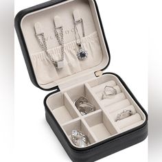 an open black case with jewelry in it