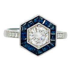 a diamond and blue sapphire ring with diamonds on the sides, set in white gold