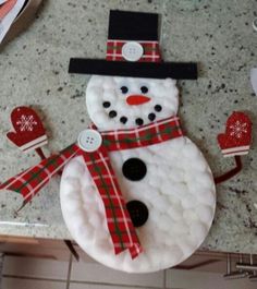 a snowman made out of cotton balls on a kitchen counter with other items around it