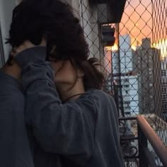 a woman standing on top of a tall building next to a fence with her head in her hands