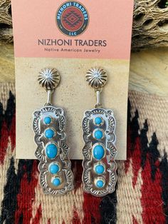 New without tags BRAND : Nizhoni Traders LLC ETHNIC & REGIONAL STYLE : Native American JEWELRY TYPE : Earrings METAL : Sterling Silver TRIBAL AFFILIATION : Navajo MAIN STONE : Turquoise Lovely Navajo Turquoise and Sterling Silver dangle earrings. Measure 2 7/8 inches long and 3/4 of an inch wide. Great pair of earrings! Stamped Sterling and signed by the artist. Thank you for checking out my store. Please contact me with any questions. Exported By exportyourstore.com Southwestern Style Blue Pierced Earrings, Southwestern Style Blue Earrings For Pierced Ears, Southwestern Blue Earrings For Pierced Ears, Artisan Blue Drop Earrings, Southwestern Style Blue Drop Earrings, Southwestern Blue Drop Earrings, Southwestern Blue Earrings For Gift, Blue Southwestern Style Earrings For Gift, Navajo Turquoise