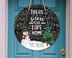 there is snow place like home sign hanging on the front door with a snowman