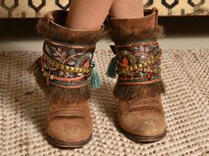 Boot covers made with base trimmings embroidered in India with floral motifs in golden cotton sequins embroidered by hand floral, decorated in an artisanal way with leather strap and old gold beads. Upper and lower edge decorated with fringes in brown mohair wool. It also has a lucky amber heart! One size: Approximate measurements: Minimum contour 32 cm and maximum contour 38 cm. Height 13cm It is tied with a buckle so it is adaptable to any boot. Exclusive products, made in limited quantities. Festival Boots With Tassels And Round Toe, Brown Embroidered Winter Boots, Western Boots With Tassels For Festival, Western Festival Boots With Tassels, Bohemian Boots With Tassels And Round Toe, Brown Tasseled Boots For Festivals, Embellished Festival Boots For Fall, Bohemian Brown Boots With Tassels, Brown Bohemian Boots With Tassels