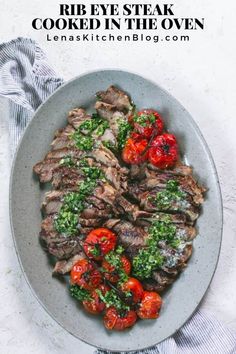 a plate full of meat and tomatoes on top of a white table cloth next to a fork