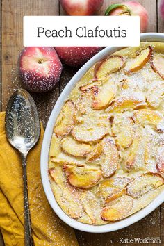 an apple cobbler with powdered sugar on top and two spoons next to it