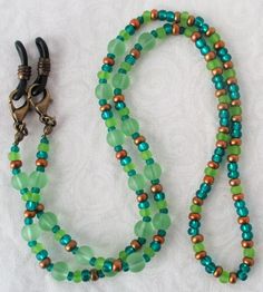 You'll always keep your reading glasses nearby using this green & brown beaded eyeglass chain! 25" in length, made with glass beads, beading cord, metal lobster clasps, and adjustable rubber holders. Lobster clasps make it easy to change the rubber holders, and an extra pair of holders included with every purchase. This green & brown beaded eyeglass chain will arrive in a gift box, ready to give as a present or to keep and store. Back to Beaded Eyeglass Chains Adjustable Green Necklace For Everyday Use, Everyday Adjustable Green Necklace, Adjustable Colorful Beaded Jewelry For Everyday Use, Adjustable Beaded Chain Necklace For Everyday, Adjustable Round Beaded Necklaces For Everyday, Adjustable Round Bead Glass Necklaces, Adjustable Green Beaded Necklaces With Lobster Clasp, Adjustable Czech Glass Beaded Necklaces With Lobster Clasp, Adjustable Green Czech Glass Beaded Necklaces