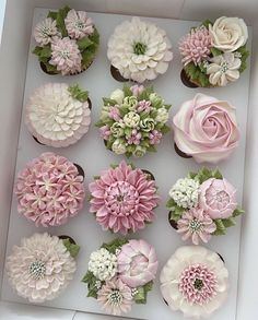 cupcakes decorated with pink and white flowers in a box