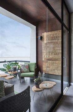 a living room filled with furniture next to a glass wall on top of a balcony