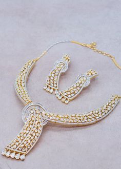 This necklace set is perfect for any occasion. It features a circular floral pattern with a baguette diamond, accompanied by a beautiful bracelet and matching earrings. The set is adorned with shimmering diamonds in chic designs, which add a touch of sparkle to any event. Whether you're treating yourself or your loved ones, this exquisite set is sure to create a lasting impression. Neckline Length: 9.75" and The length of the necklace is adjustable by a chain. Earrings Length: Approx. 2.5" Weigh Dazzling Hand-set Yellow Gold Necklace, Diamond Necklace Set Indian, Luxury Multi-stone Evening Jewelry, Luxury Gold-tone Dangle Necklaces, Elegant Multicolor Stone-set Jewelry, Jewelry Combo, Luxury 22k Gold Hand-set Necklace, Baguette Diamond Necklace, Indian Choker