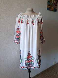 White tunic dress with multicolor floral embroidery, long wide sleeves, elasticated neckline, loose fit with lining. Composition - 100% viscose, marked size L XL. Measurements are taken in horizontal position: Armpit to armpit - 52 cm/20,5'' Length - 83 cm/ 32,6'' Very good condition, on the last pictures you can see loose threads on embroidery. White Long Sleeve Peasant Embroidered Dress, White Peasant Embroidered Long Sleeve Dress, Peasant Style Long Sleeve Embroidered Dress, Long Sleeve Embroidered Folk Peasant Dress, Folk Style Long Sleeve Embroidered Peasant Dress, Long Sleeve Folk Peasant Dress For Spring, Long Sleeve Tunic With Floral Embroidery For Vacation, Long Sleeve Floral Embroidery Tunic For Vacation, Long Sleeve Multicolor Embroidered Summer Tunic