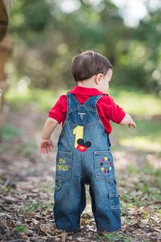 a little boy that is standing up in the dirt with his hands out and looking at something