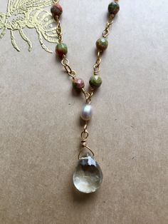 "A handmade chain of 12 faceted Unakite beads leads to a sparkling, faceted Green Amethyst drop hanging by a small Fresh Water Pearl. The closure features an additional Unakite bead. - 18\" long - gold-fill chain - Unakite, Pearl, and Green Amethyst - strong gold-fill clasp Arrives in a beautifully wrapped box with a gold-embossed bee design on the cover, a ribbon, and matching tissue paper." Adjustable Wire Wrapped Drop Jewelry, Artisan Jewelry With Faceted Beads As A Gift, Artisan Jewelry With Faceted Beads For Gifts, Elegant Beaded Necklaces With Teardrop Natural Stones, Artisan Faceted Round Beads Jewelry, Elegant Teardrop Beaded Necklaces With Natural Stones, Elegant Teardrop Beaded Necklace With Natural Stones, Artisan Necklace With Faceted Beads For Gifts, Artisan Pendant Jewelry With Faceted Beads