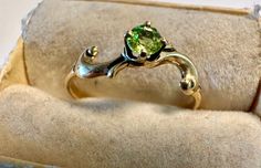 a gold ring with a green stone in it