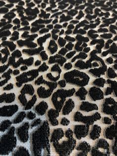 an animal print fabric with black and white spots on it's surface is shown