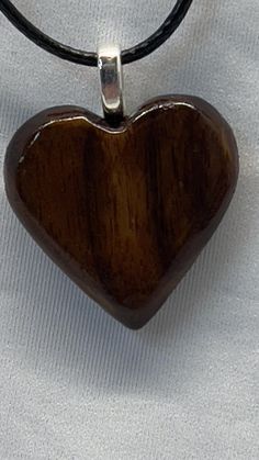 Hand shaped wood heart pendant necklace, Made from solid walnut hardwood. Finished with a beautiful luster. Silver loop and black cord and lobster claw clasp Necklace Wood, Heart Hands, Wood Hearts, Hand Shapes, Solid Walnut, Heart Pendant Necklace, Lobster Claw, Heart Pendant, Pendant Necklaces