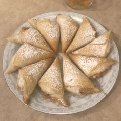 several pastries on a plate next to a glass of orange juice and an apple cider