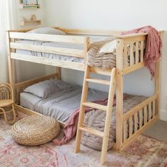 a wooden bunk bed sitting next to a rug on top of a carpeted floor