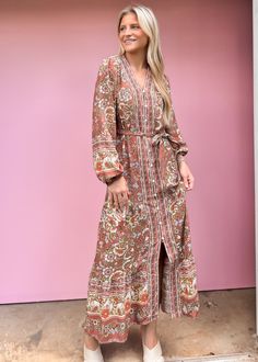 Say hello to your new go-to dress! Our Camellia Floral Maxi Dress features a playful floral print, long sleeves, and a flattering V-neckline. The lightweight and flowy fabric make it perfect for any occasion, while the belted waist adds an extra touch of flirty fun. Available in two colors, this dress is sure to turn heads at any event. True to size Olivia is 5'7 wearing small Color: Brown All over floral print maxi dress Functioning front buttons Adjustable tie belt V-Neck Long-sleeves Not lined Non-sheer. Lightweight Fabric: 100% Viscose Fabric has no stretch Bohemian V-neck Belted Dress, Flowy Tie Waist Maxi Dress For Fall, Flowy Tie-waist Maxi Dress For Fall, Flowy Maxi Dress With Tie Waist For Fall, Bohemian Belted V-neck Maxi Dress, Flowy Long Sleeve Belted Dresses, Floral Print Long Sleeve Rayon Dresses, Long Sleeve Floral Print Rayon Dresses, Flowy Long Sleeve Belted Maxi Dress