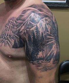 Crosses, forest, mountains, and sunlight decorate this shoulder-chest-half sleeve in a black & grey realism style tattoo by Josh Schuver at Artistic Edge Tattoo & Piercing in Rome, GA Landscape Chest Tattoo, Mountain Chest Tattoo Men, Mountain Tattoo Shoulder, Tattoo Berge, Tattoo Chest And Shoulder, Men Chest Tattoo, Crosses Tattoo, Shoulder Tattoo Men, Edge Tattoo