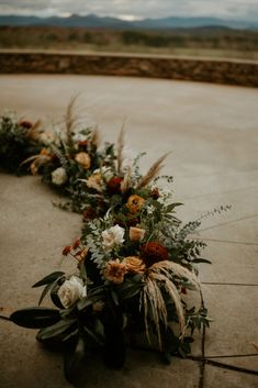 A low, semi-circle arrangement designed with shades of terra cotta and red with eucalyptus, magnolia, pampas grass, roses, mums, and more. Magnolia Wedding Bouquet Fall, Pampas Grass Floral Arrangements, Magnolias Wedding Bouquet, Mum Wedding, Event Florals, Wedding Isles, Magnolia Wedding, Wedding Aisle Decorations, Wedding Vision