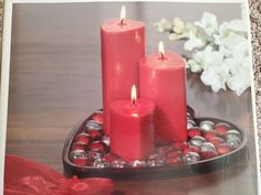 three red candles sitting on top of a tray