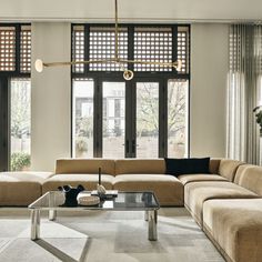 a living room filled with furniture and large windows