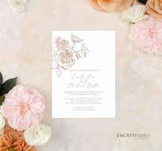 the wedding card is surrounded by flowers and greenery