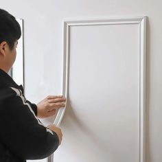 a man is painting the wall with white paint