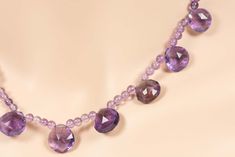 "Genuine Amethyst Necklace made with beautiful high quality purple faceted briolettes. The briolettes are separated by 4mm round Amethyst beads and it is closed with a Sterling Silver lobster clasp. The briolettes are 12mm x 13mm and the total length of the necklace is 18\". To view the entire collection of necklaces: https://www.etsy.com/shop/HealingGemstone?section_id=14348860&ref=shopsection_leftnav_1 To return to the store: https://www.etsy.com/shop/HealingGemstone The necklace comes in Elegant Purple Faceted Beads Gemstones, Faceted Amethyst Briolette Necklace, Purple Amethyst Briolette Necklace, Purple Briolette Amethyst Necklace, Amethyst Briolette Necklace With Gemstone Accents, Amethyst Briolette Necklace With Faceted Beads, Faceted Amethyst Briolette Gemstones, Faceted Lavender Briolette Jewelry, Purple Briolette Crystal Gemstone Necklace