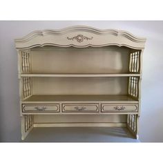 an antique white bookcase with drawers